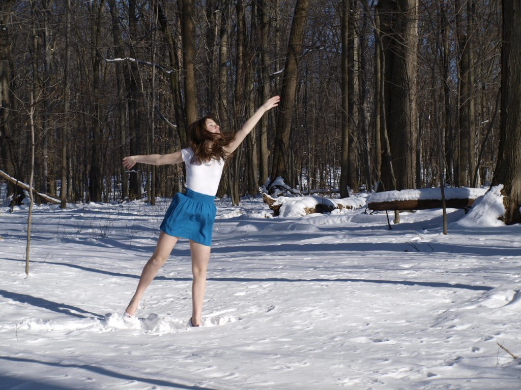 jeune-fille-en-ballerines-et-mini-jupe-bleue-dans-la-neige